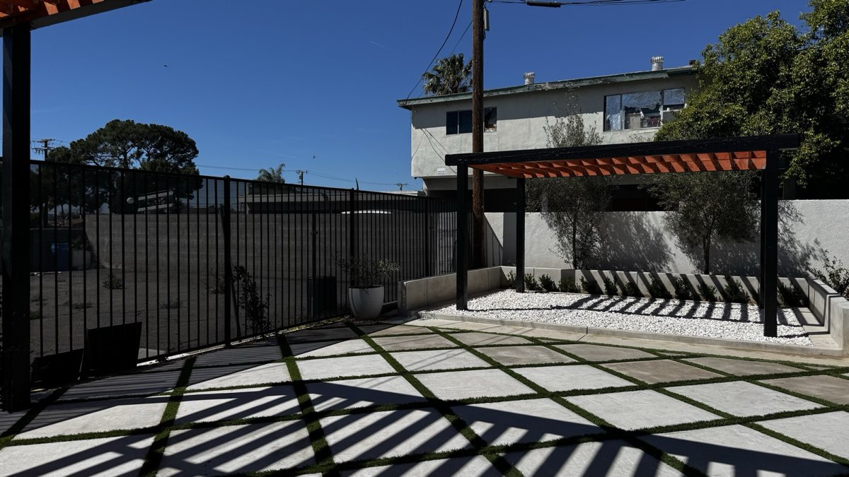 Paver courtyard with grass joints leading to the pergola patio